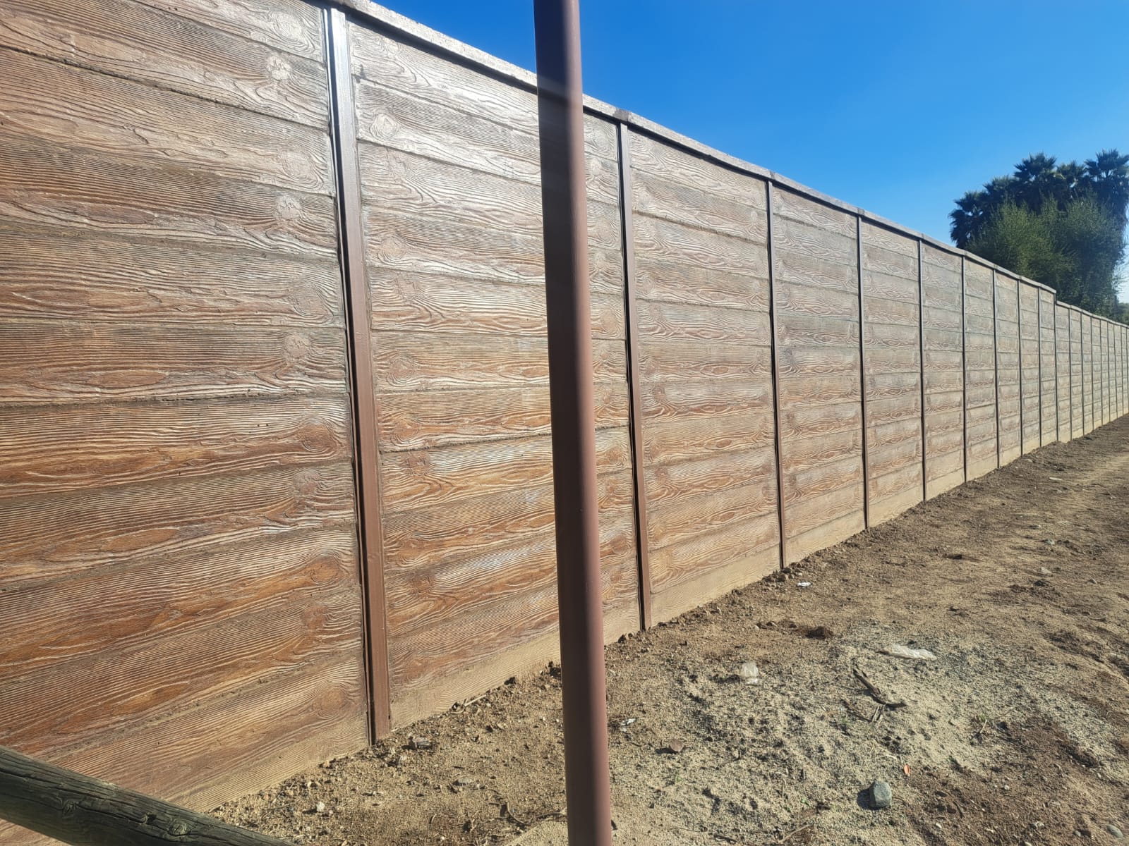 Cierre perimetral de hormigón vibrado estilo madera instalado por JC Inversiones